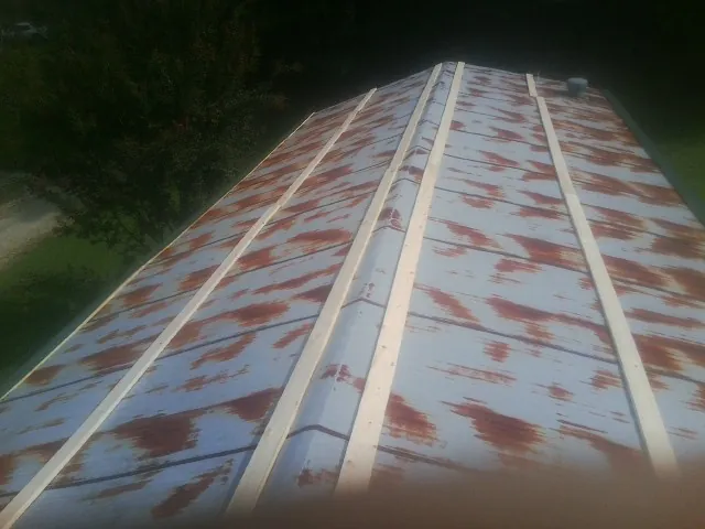 Rusted metal roof panels with new wood purlins before replacement — Storm Damage Roof Repair in Sunapee by Roofing Brothers