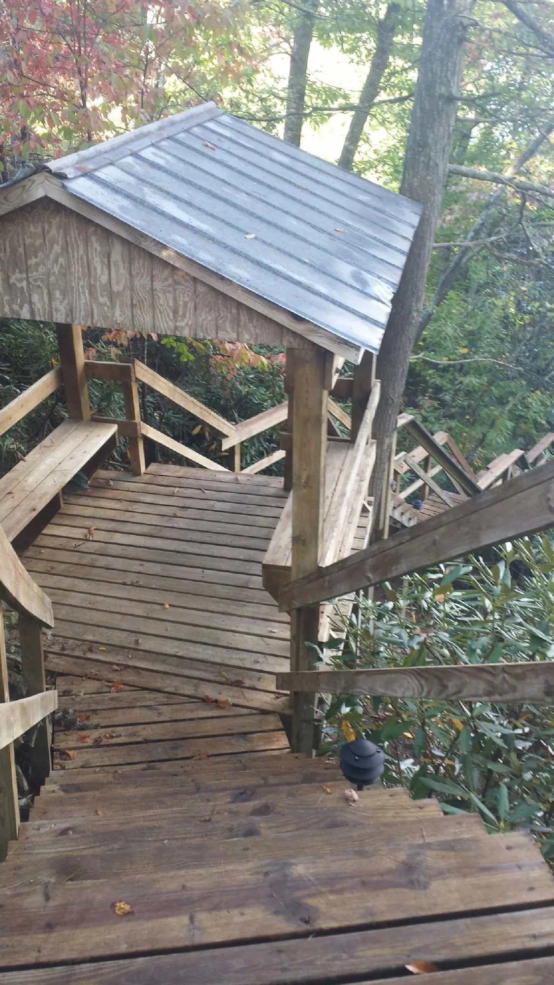 Metal roofed shelter over wooden steps on a wooded walkway — Skylight Repair & Installation work by our crew in Sunapee