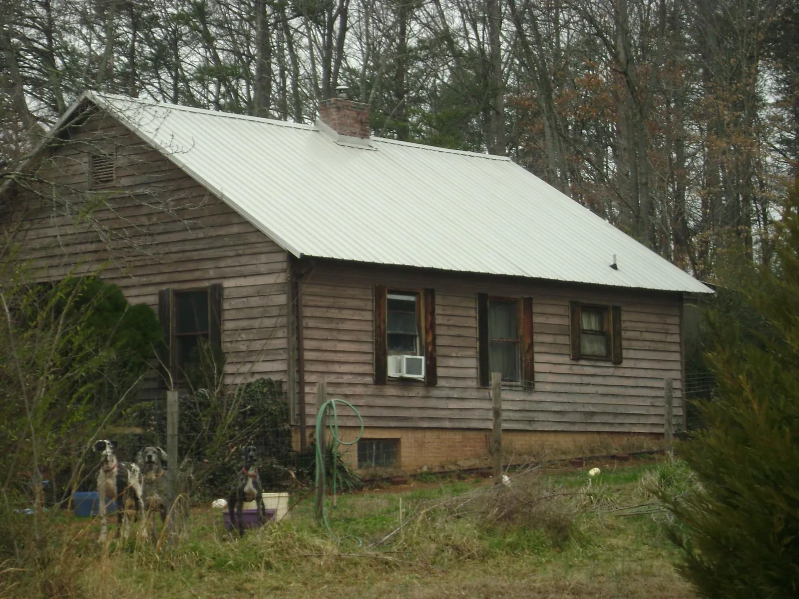 White metal roof on an old wood sided farmhouse, from a Metal Roof Installation job in Sunapee